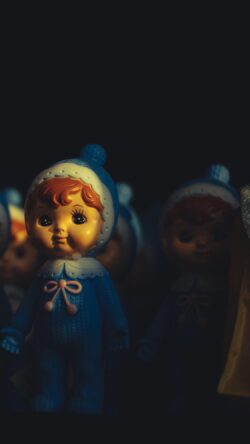 vintage dolls retro toys nostalgia childhood memories antique figurines blue doll outfit collectible toys moody lighting toy photography classic toys aesthetic display kitsch plastic figures