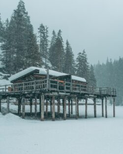 winter boathouse snow covered wooden pier frozen lake snowstorm alpine hut snowy forest Dolomiti cold weather winter landscape rustic architecture isolated building wilderness white environment sc