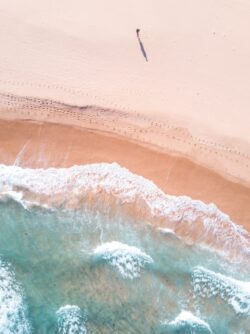 beach aerial view ocean wave sand turqouise blue water footprints minimal nature coastline summer solitude clean