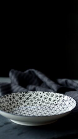 ceramic bowl patterned dish kitchenware tableware minimal monochrome geometry design interior dark background table setting still life clean
