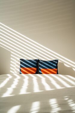 sunlight shadows blinds pattern bedroom interior modern decor geometric pillows abstract lighting minimalist living aesthetic home serenity morning light interior design cozy atmosphere