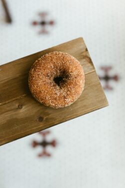 donut cinnamon sugar pastry dessert sweet snack bakery wood tray minimalist food flat lay delicious breakfast doughnut treat