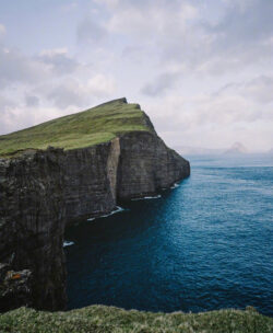 faroe islands cliffs ocean green hills rugged nature coastline scenic travel adventure dramatic landscape nordic hiking blue water remote